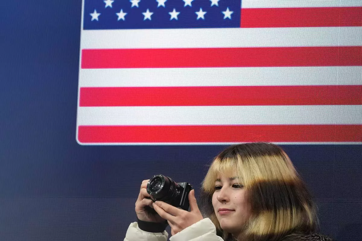 Alysa Liu of the United States takes photos before the figure skating men's team event at the 2026 Winter Olympics, in Milan, Italy, Saturday, Feb. 7, 2026. (AP Photo/Francisco Seco)