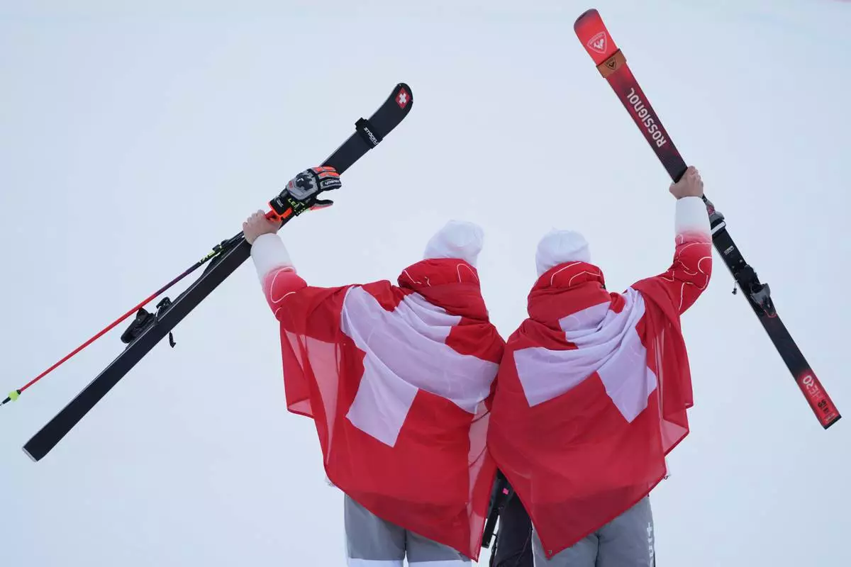 Silver medalist Switzerland's Marco Odermatt, left, and bronze medalist Switzerland's Loic Meillard show their medals for an alpine ski, men's giant slalom race, at the 2026 Winter Olympics, in Bormio, Italy, Saturday, Feb. 14, 2026. (AP Photo/Rebecca Blackwell)