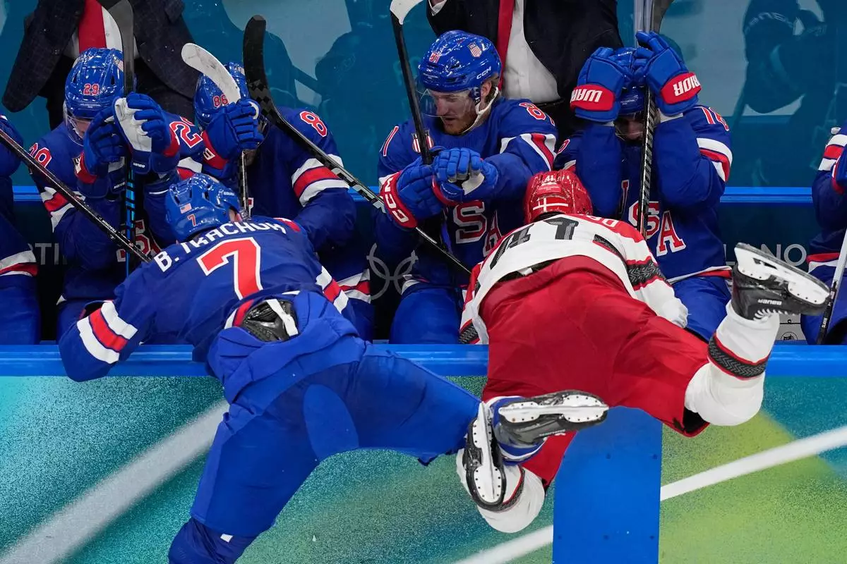 United States' Brady Tkachuk, left, challenges Denmark's Jesper Jensen Aabo during a preliminary round match of men's ice hockey between United States and Denmark at the 2026 Winter Olympics, in Milan, Italy, Saturday, Feb. 14, 2026. (AP Photo/Petr David Josek)