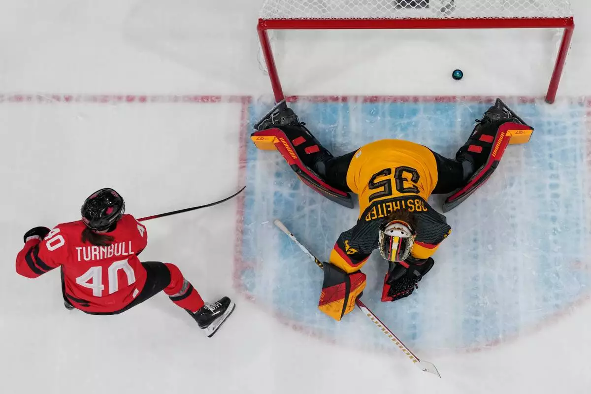 Canada's Blayre Turnbull (40) scores her side's fourth goal during a women's quarterfinal ice hockey game between Canada and Germany at the 2026 Winter Olympics, in Milan, Italy, Saturday, Feb. 14, 2026. (AP Photo/Darko Bandic)