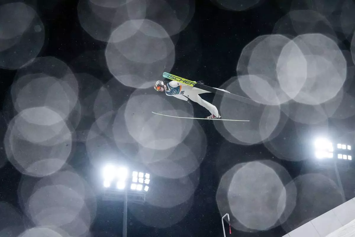 Kacper Tomasiak, of Poland, soars through the air during the ski jumping men's large hill individual at the 2026 Winter Olympics, in Predazzo, Italy, Saturday, Feb. 14, 2026. (AP Photo/Evgeniy Maloletka)