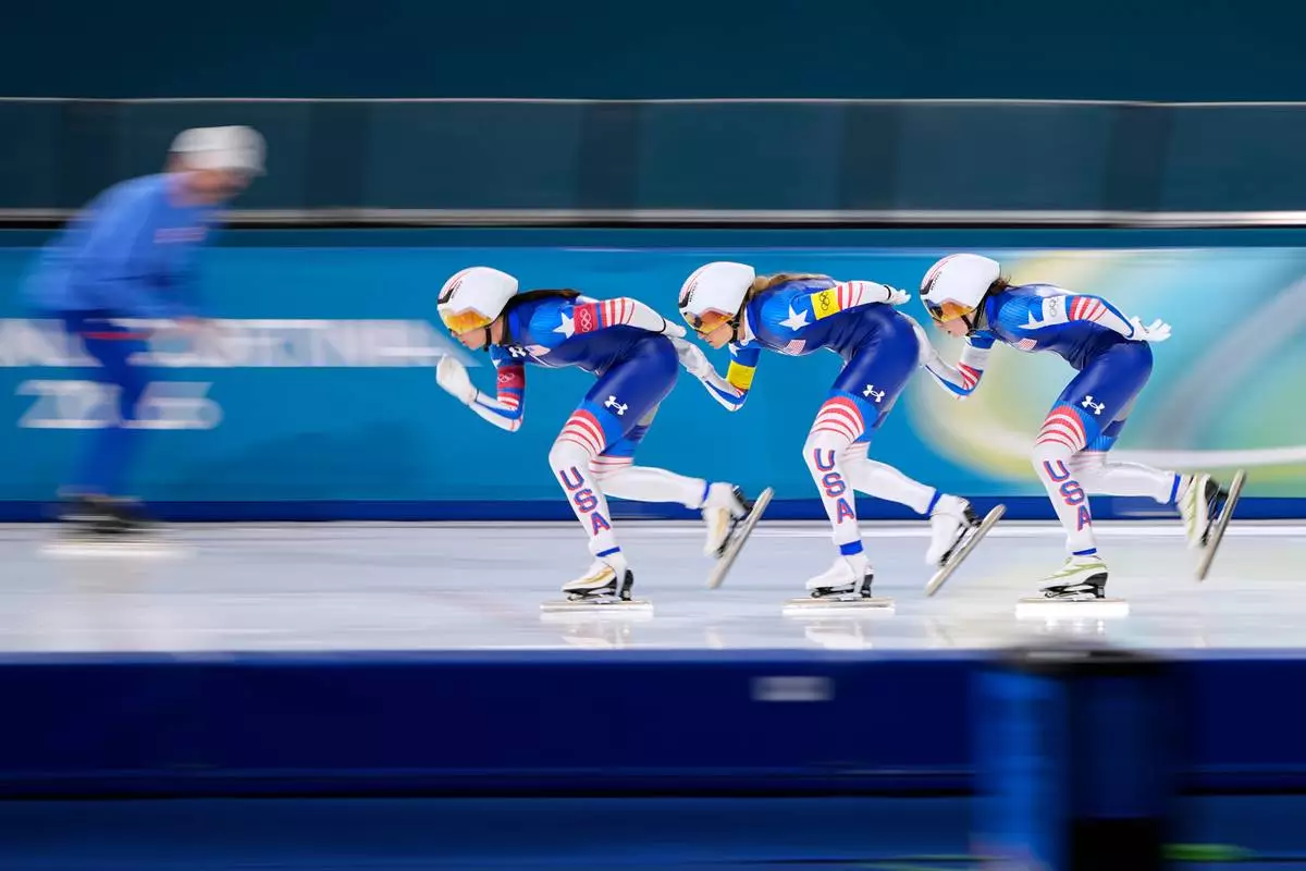 Brittany Bowe of the U.S., front, is followed by teammates Mia Manganello, center, and Giorgia Birkeland, right, as they compete in the women's team pursuit quarterfinals speedskating race at the 2026 Winter Olympics, in Milan, Italy, Saturday, Feb. 14, 2026. (AP Photo/Ben Curtis)