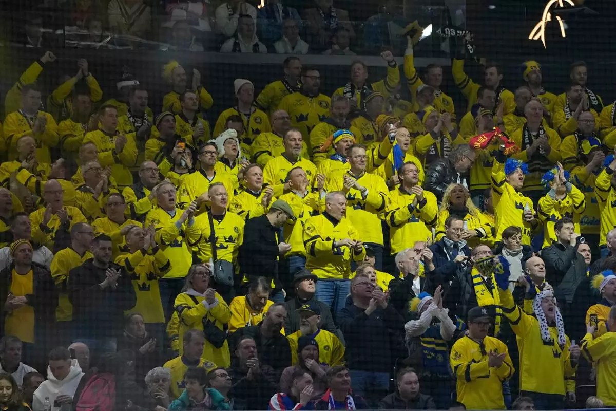 Swedish fans cheer during a preliminary round match of men's ice hockey between Sweden and Slovakia at the 2026 Winter Olympics, in Milan, Italy, Saturday, Feb. 14, 2026. (AP Photo/Petr David Josek)