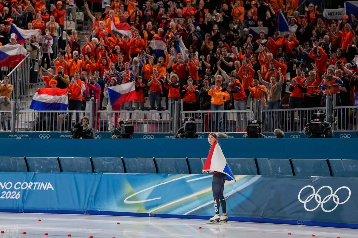 Merel Conijn of the Netherlands celebrates winning a silver medal with Dutch fans in the women's 5,000 meters speedskating race at the 2026 Winter Olympics, in Milan, Italy, Thursday, Feb. 12, 2026. (AP Photo/Ben Curtis)