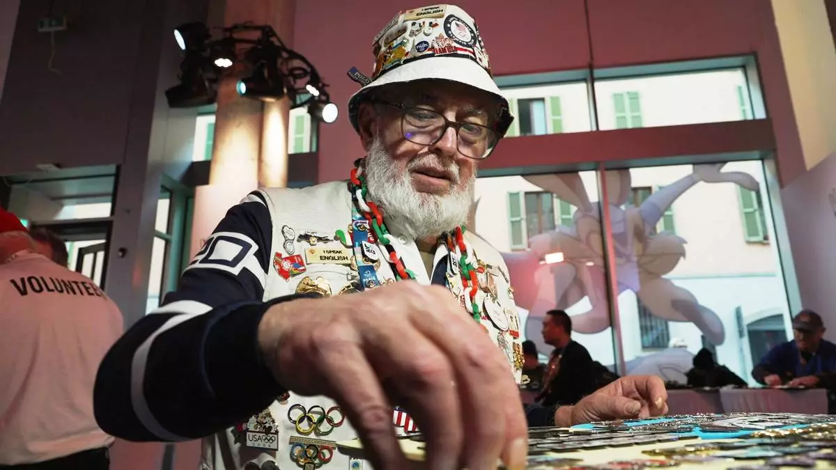 Pin collector Eddie Schneider of Lindenhurst, NY organizes his trading stock at the official Olympic pin center, at the 2026 Winter Olympics, in Milan, Italy, Wednesday, Feb. 11, 2026. (AP Photo/Mustakim Hasnath)