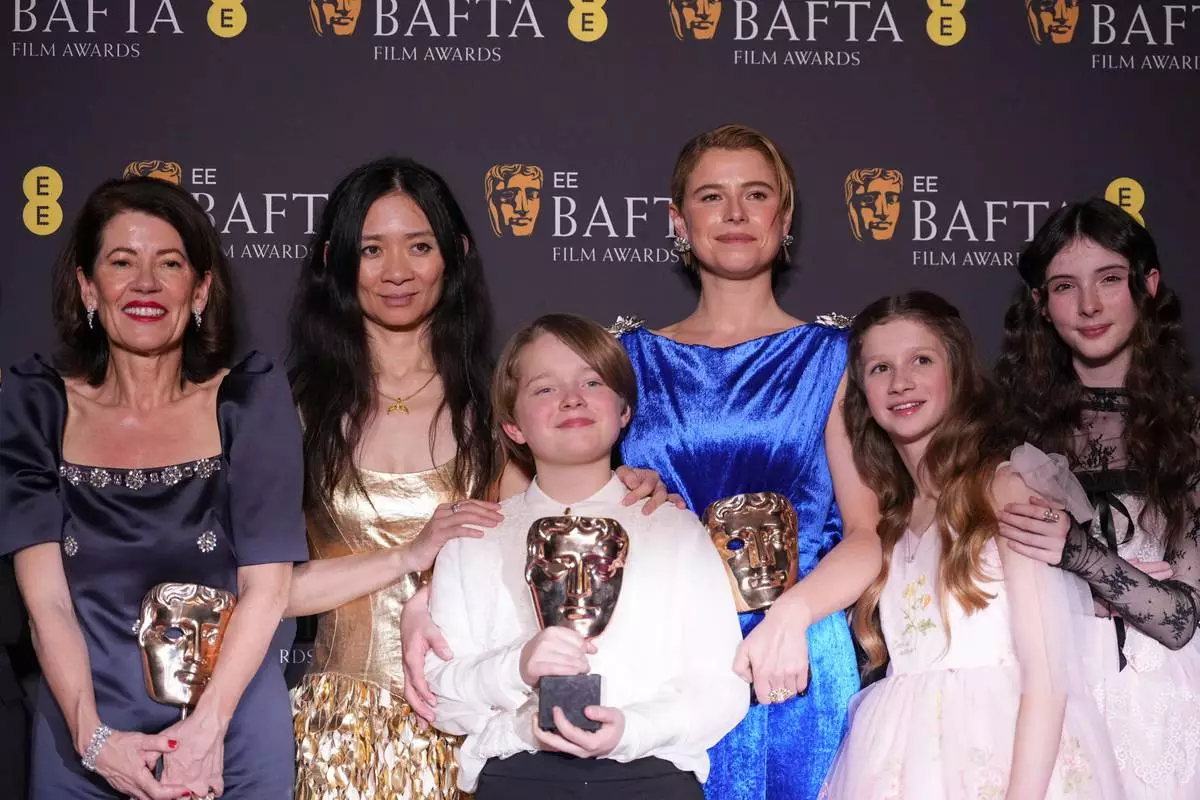 Pippa Harris, from left, Chloe Zhao, Jacobi Jupe, Jessie Buckley, Olivia Lynes, and Bodhi Rae Breathnach pose with the award for outstanding British film for 'Hamnet' at the 79th British Academy Film Awards, BAFTA's, in London, Sunday, Feb. 22, 2026. (AP Photo/Alastair Grant)