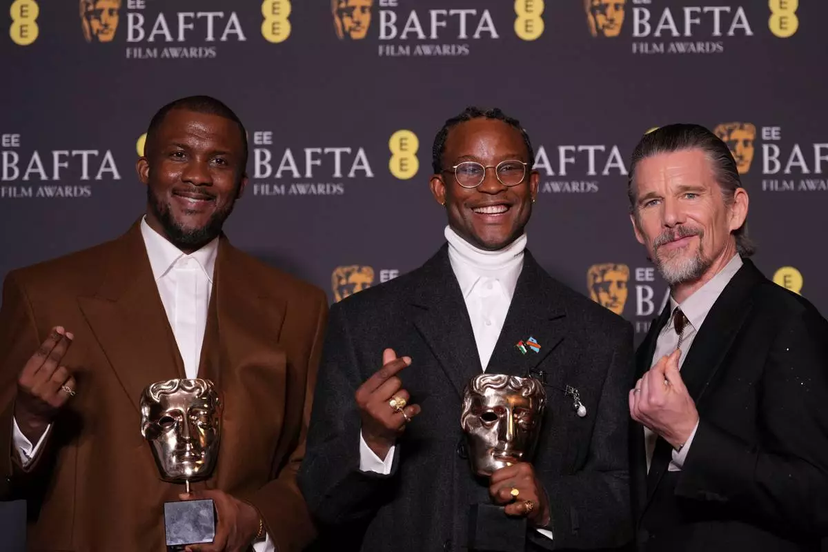 Wale Davies, from left, Akinola Davies Jr., and Ethan Hawke pose with the award for outstanding debut by a British writer, director or producer for 'My Father's Shadow' at the 79th British Academy Film Awards, BAFTA's, in London, Sunday, Feb. 22, 2026. (AP Photo/Alastair Grant)