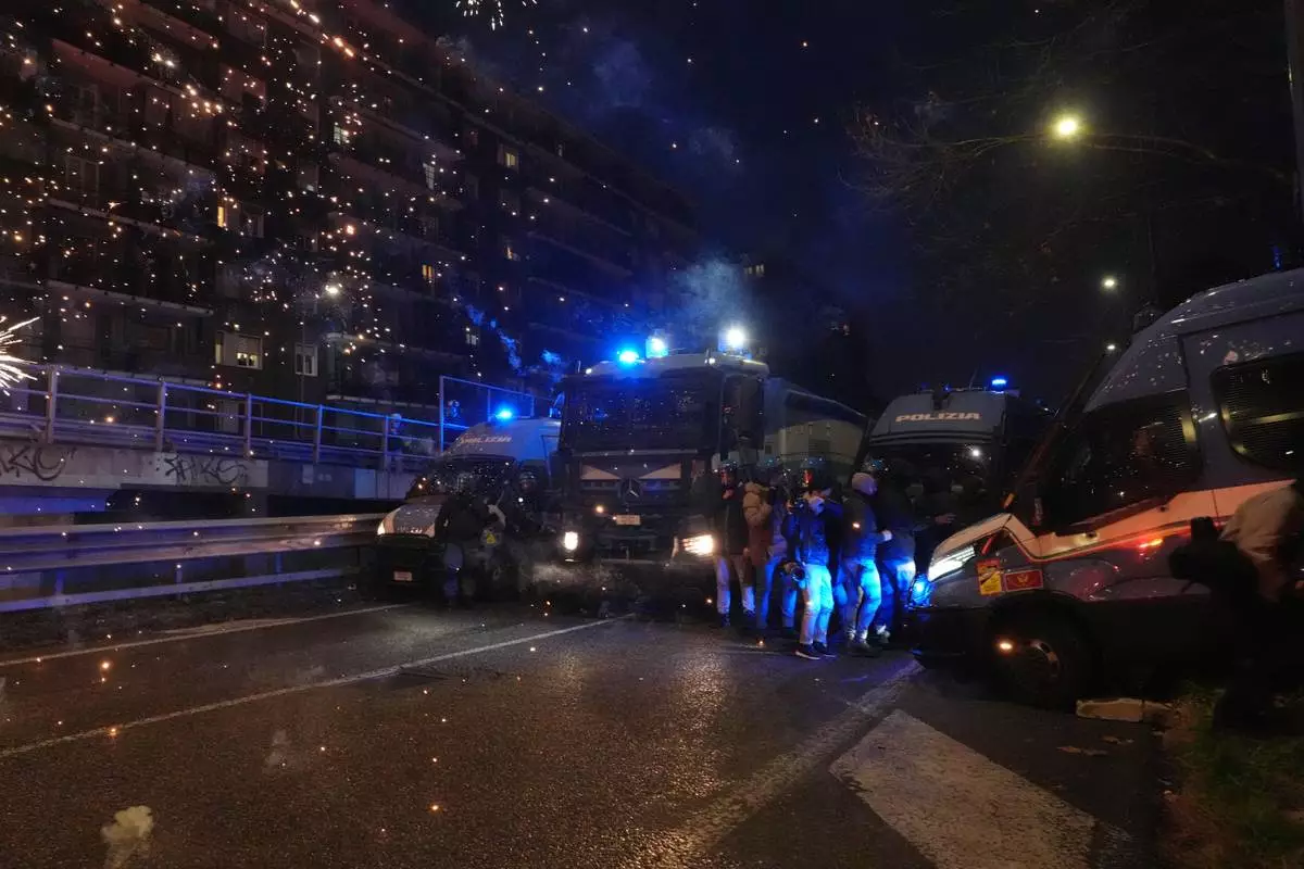 Police officers block the street in from of demonstrators marching against the Milan-Cortina 2026 Olympics, in Milan, Italy, Saturday Feb. 7, 2026. (Claudio Furlan/LaPresse via AP)