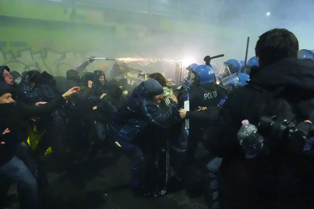 Demonstrators clash with police during a protest against the Milan-Cortina 2026 Olympics, in Milan, Italy, Saturday Feb. 7, 2026. (Claudio Furlan/LaPresse via AP)