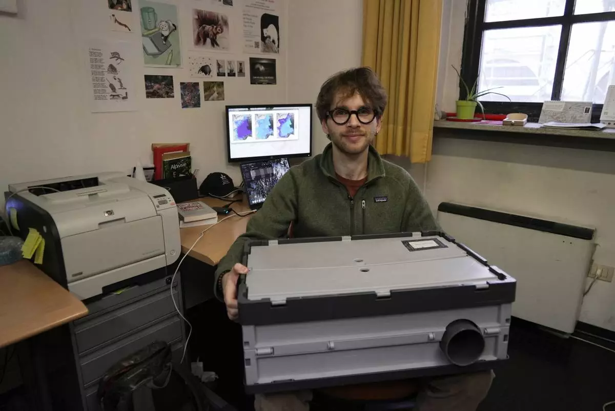 Doctoral student Marco Granata holds an Alpine Mostela, a device he uses to film stoats in their mountain habitat, Wednesday, Feb. 11, 2026, in Turin, Italy. (AP Photo/Brittany Peterson)