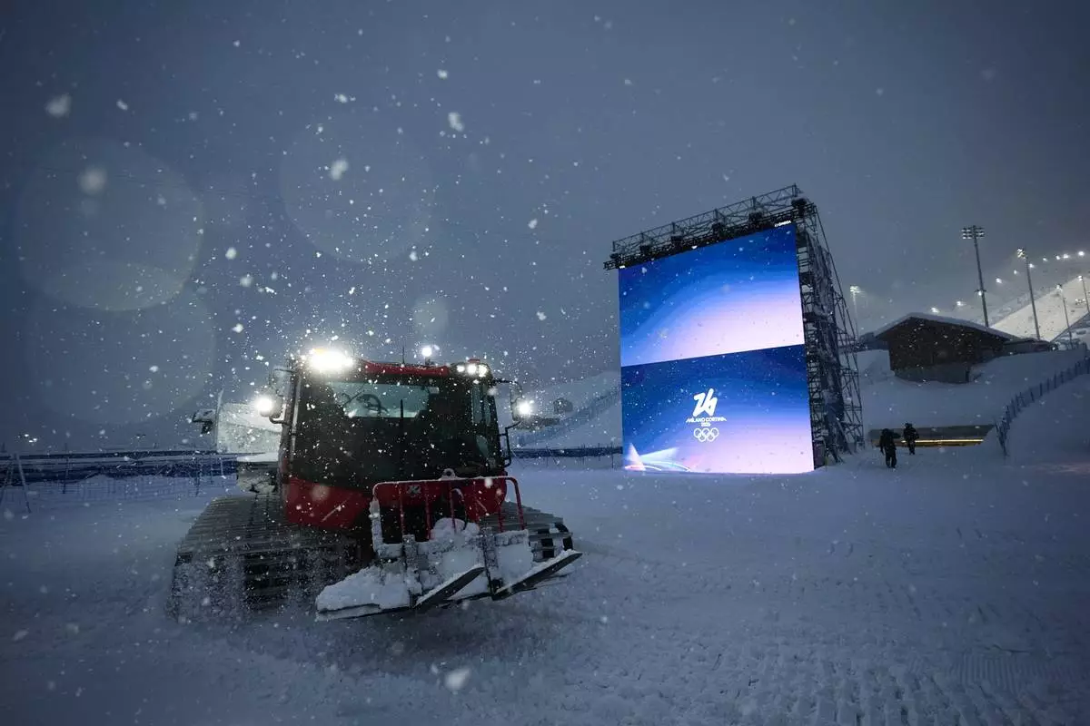 Snowcat driver Oliviero Galli cleans up courses after a weather delay postponed the women's freestyle skiing halfpipe final at the 2026 Winter Olympics, in Livigno, Italy, Saturday, Feb. 21, 2026. (AP Photo/Andy Bao)