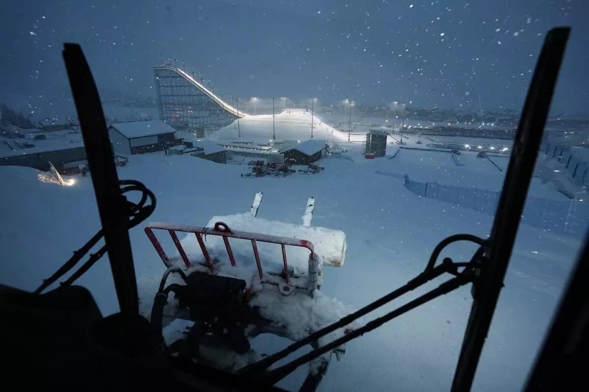 Snowcat driver Oliviero Galli cleans up courses after a weather delay postponed the women's freestyle skiing halfpipe final at the 2026 Winter Olympics, in Livigno, Italy, Saturday, Feb. 21, 2026. (AP Photo/Andy Bao)