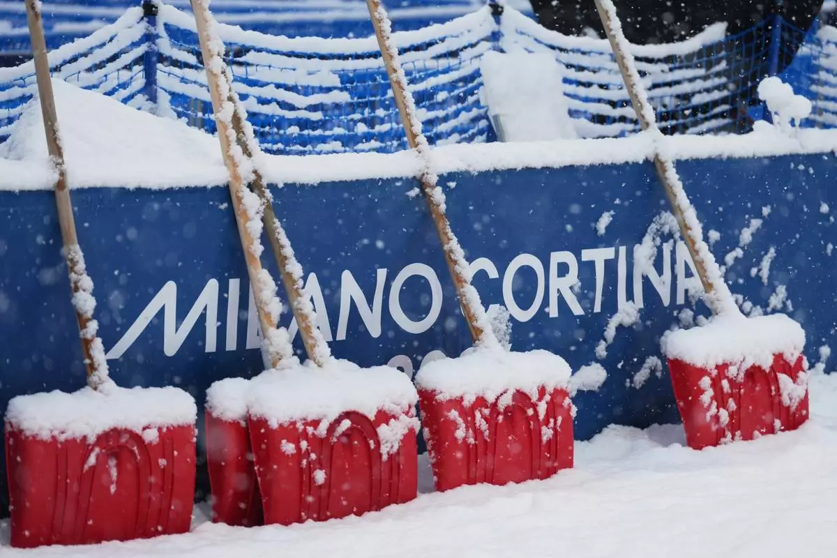 Heavy snow falls on shovels during a weather delay before the women's freestyle skiing halfpipe final at the 2026 Winter Olympics, in Livigno, Italy, Saturday, Feb. 21, 2026. (AP Photo/Lindsey Wasson)