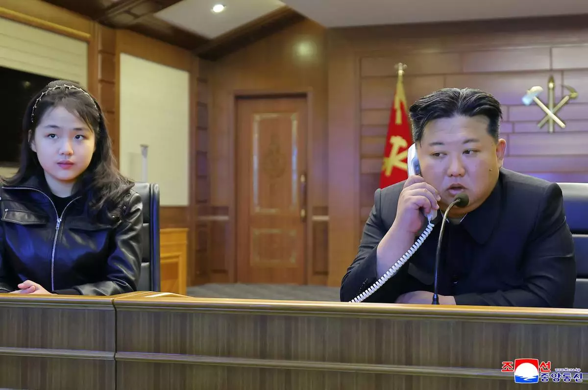 This photo provided by the North Korean government shows its leader Kim Jong Un, right, and his daughter, left, watch what it says the cruise missiles launches from the naval destroyer, the Choe Hyon, via video Tuesday, March 10, 2026, in North Korea. Independent journalists were not given access to cover the event depicted in this image distributed by the North Korean government. The content of this image is as provided and cannot be independently verified. Korean language watermark on image as provided by source reads: "KCNA" which is the abbreviation for Korean Central News Agency. (Korean Central News Agency/Korea News Service via AP)