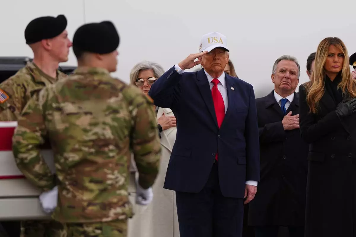 President Donald Trump salutes as an Army carry team moves the flag-draped transfer case containing the remains of U.S. Army Reserve Sgt. 1st Class Noah Tietjens, 42, of Bellevue, Neb., who was killed in a drone strike at a command center in Kuwait after the U.S. and Israel launched its military campaign against Iran, during a casualty return Saturday, March 7, 2026, at Dover Air Force Base, Del. At right is first lady Melania Trump and White House Special Envoy to the Middle East Steve Witkoff. (AP Photo/Julia Demaree Nikhinson)