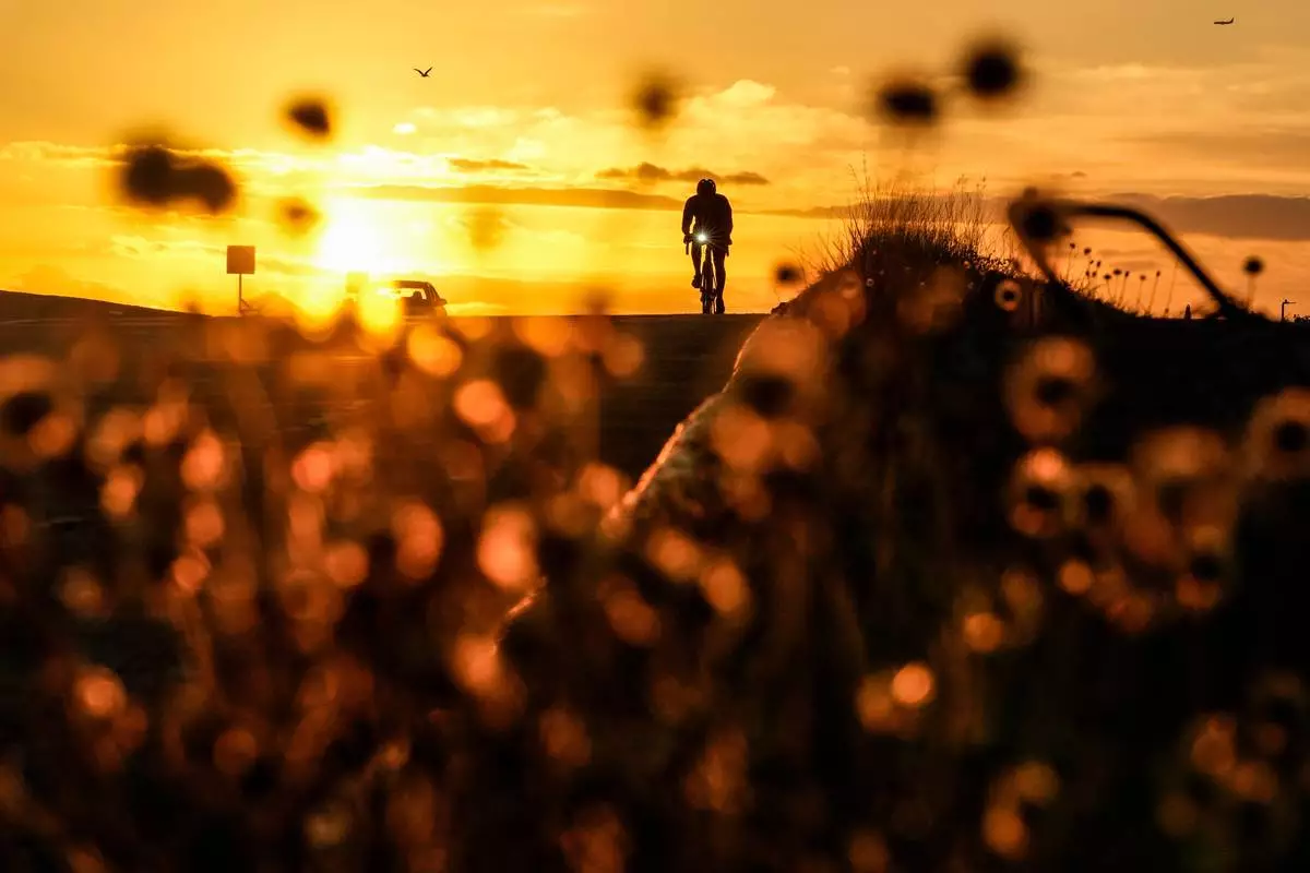 A cyclist rides on a coastal road at sunrise in Panama City, Wednesday, March 25, 2026. (AP Photo/Matias Delacroix)