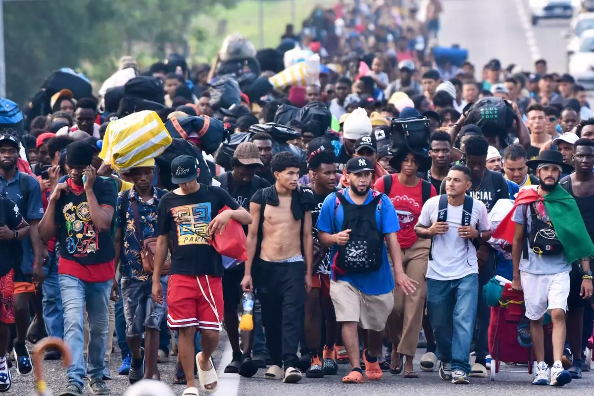 Migrants walk on the highway through the municipality of Huehuetan, Chiapas state, Mexico, Wednesday, March 25, 2026, after leaving Tapachula the previous night. (AP Photo/Edgar H. Clemente)