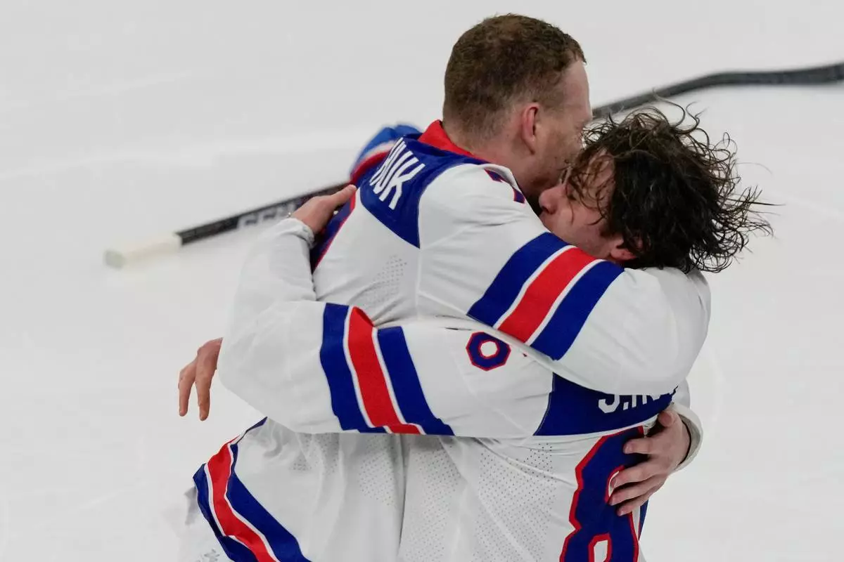 United States' Jack Hughes (86) celebrates with United States' Brady Tkachuk (7) after scoring the game-winning goal against Canada in sudden death overtime during the men's ice hockey gold medal game at the 2026 Winter Olympics, in Milan, Italy, Sunday, Feb. 22, 2026. (AP Photo/Luca Bruno)