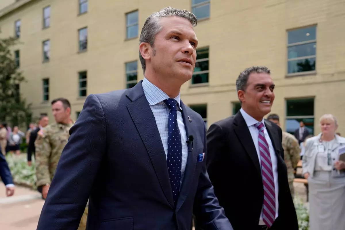 FILE- Secretary of Defense Pete Hegseth, left, and Under Secretary of Defense for Research and Engineering Emil Michael, right, arrive to look at a display of multi-domain autonomous systems in the Pentagon courtyard, Wednesday, July 16, 2025, in Washington. (AP Photo/Julia Demaree Nikhinson, File)