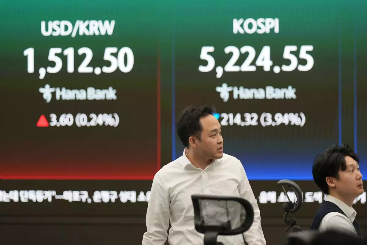 Dealers work near the screens showing the Korea Composite Stock Price Index (KOSPI), right, and the foreign exchange rate between U.S. dollar and South Korean won at a dealing room of Hana Bank in Seoul, South Korea, Monday, March 30, 2026. (AP Photo/Lee Jin-man)
