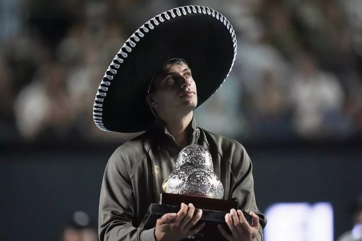 FILE - Flavio Cobolli of Italy holds the trophy after winning the men's singles final match against Frances Tiafoe of the U.S. at the Mexican Open tennis championship in Acapulco, Mexico, Feb. 28, 2026. (AP Photo/Eduardo Verdugo, File)