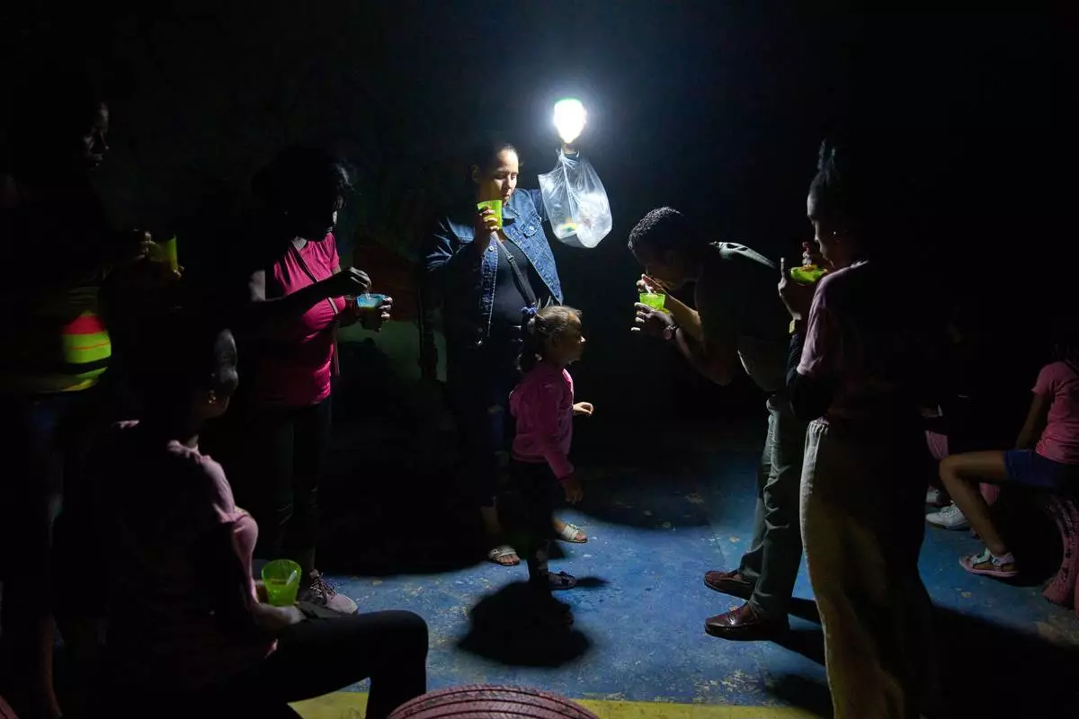 FILE - People eat cups of soup outside during a blackout in Havana, March 4, 2026. (AP Photo/Ramon Espinosa, File)