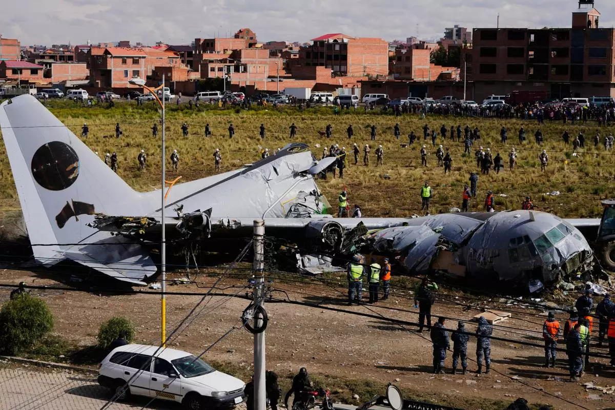 FILE - Military police stand next to a cargo plane that crashed on a highway in El Alto, Bolivia, Feb. 28, 2026. (AP Photo/Juan Karita, File)