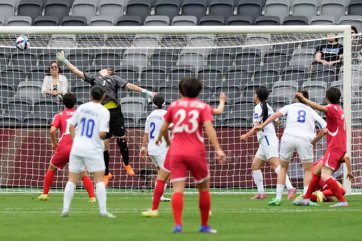 North Korea's Myong Yu Jong, right, kicks the ball past Uzbekistan's goalkeeper Maftuna Jonimqulova to score her team's first goal during the Women's Asia Cup soccer match between North Korea and Uzbekistan in Sydney, Tuesday, March 3, 2026. (AP Photo/Rick Rycroft)