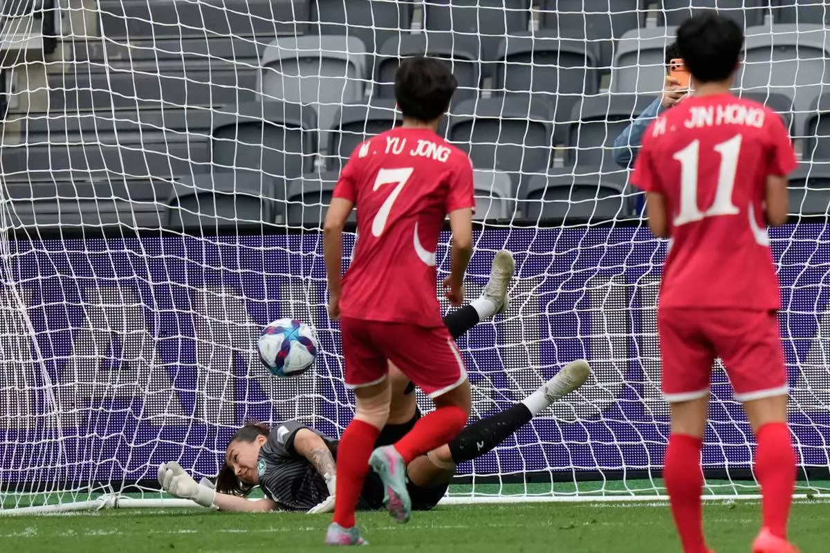 North Korea's Myong Yu Jong, centre, scores from the penalty spot as Uzbekistan's goalkeeper Zarina Saidova dives during the Women's Asia Cup soccer match between North Korea and Uzbekistan in Sydney, Tuesday, March 3, 2026. (AP Photo/Rick Rycroft)