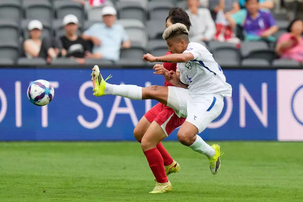 Uzbekistan's Dilrabo Asadova right, battles for the ball with North Korea's Chae Un Yong during the Women's Asia Cup soccer match between North Korea and Uzbekistan in Sydney, Tuesday, March 3, 2026. (AP Photo/Rick Rycroft)