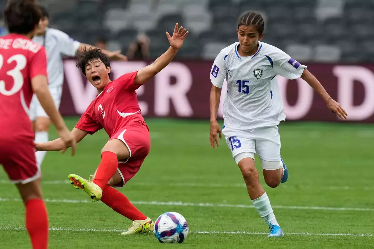 North Korea's Ri Myong gum, left, and Uzbekistan's Umida Zoirova compete for the ball during the Women's Asia Cup soccer match between North Korea and Uzbekistan in Sydney, Tuesday, March 3, 2026. (AP Photo/Rick Rycroft)