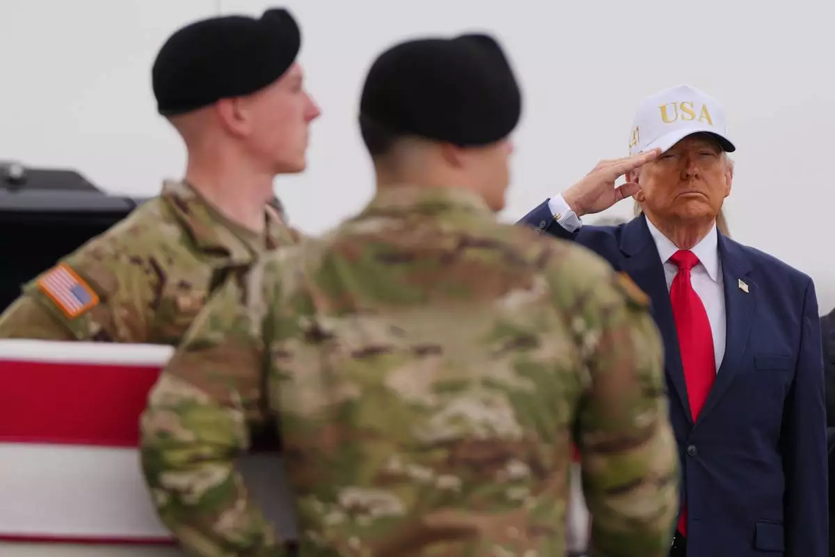 President Donald Trump salutes as an Army carry team moves the flag-draped transfer case containing the remains of U.S. Army Reserve Sgt. Declan Coady, 20, of West Des Moines, Iowa, who was killed in a drone strike at a command center in Kuwait after the U.S. and Israel launched its military campaign against Iran, during a casualty return Saturday, March 7, 2026, at Dover Air Force Base, Del. (AP Photo/Julia Demaree Nikhinson)