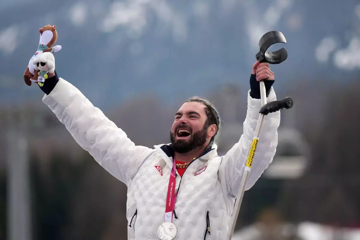Patrick Halgren, of the United States, celebrates on the podium after winning the silver medal in the alpine skiing men's super-G standing at the 2026 Winter Paralympics, in Cortina d'Ampezzo, Italy, Monday, March 9, 2026. (AP Photo/Emilio Morenatti)