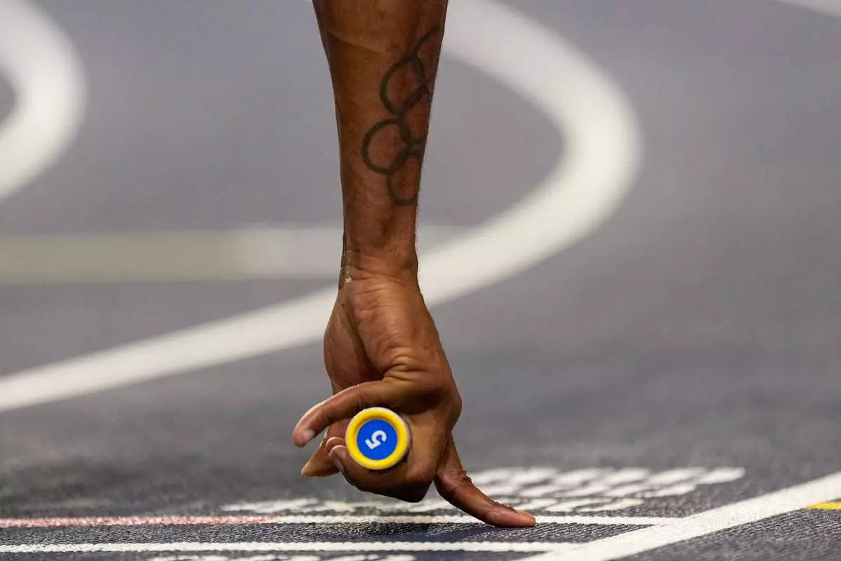 Elija Godwin, of United States, hold a baton prior to the start of a men's 4 X 400 meters relay heat at the World Athletics Indoor Championships in Torun, Poland, Sunday, March 22, 2026. (AP Photo/Petr David Josek)