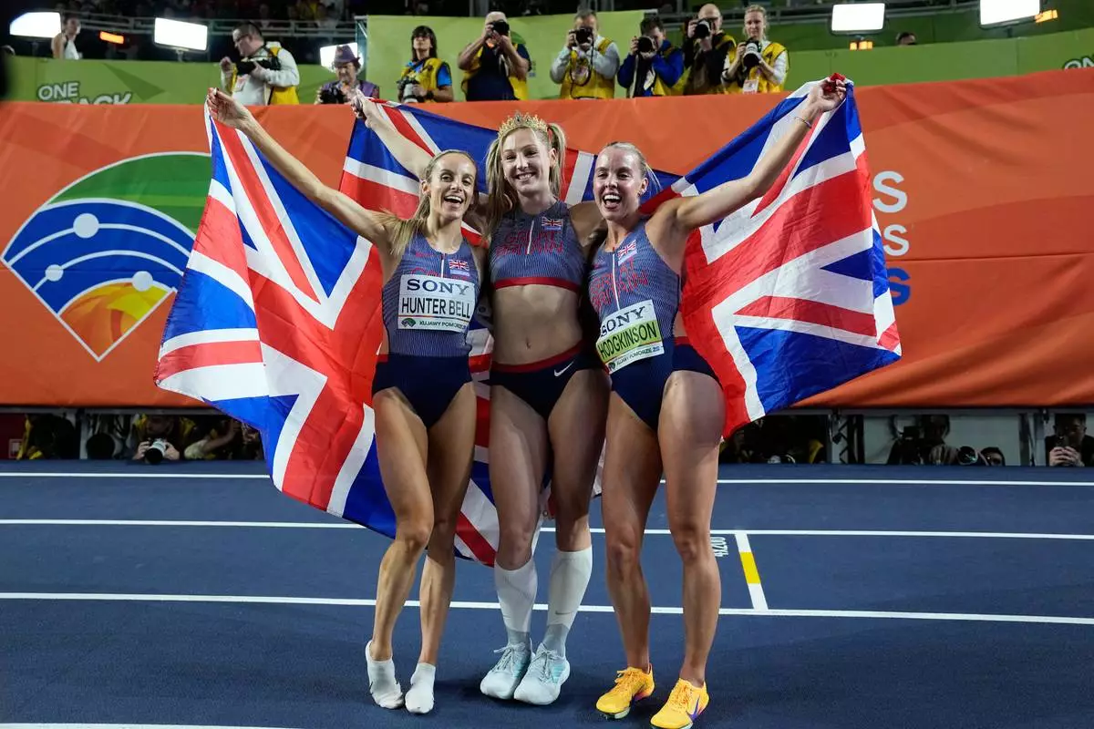 Gold medalists Georgia Hunter Bell, Molly Caudery and Keely Hodgkinson, all three of of Britain, pose together after winning their events at the World Athletics Indoor Championships in Torun, Poland, Sunday, March 22, 2026. (AP Photo/Matthias Schrader)