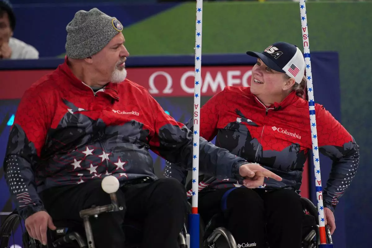 Stephen Emt of the United States gestures with Laura Dwyer as they compete against Estonia in a wheelchair curling mixed doubles round robin session at the 2026 Winter Paralympics, in Cortina d'Ampezzo, Italy, Thursday, March 5, 2026. (AP Photo/Emilio Morenatti)