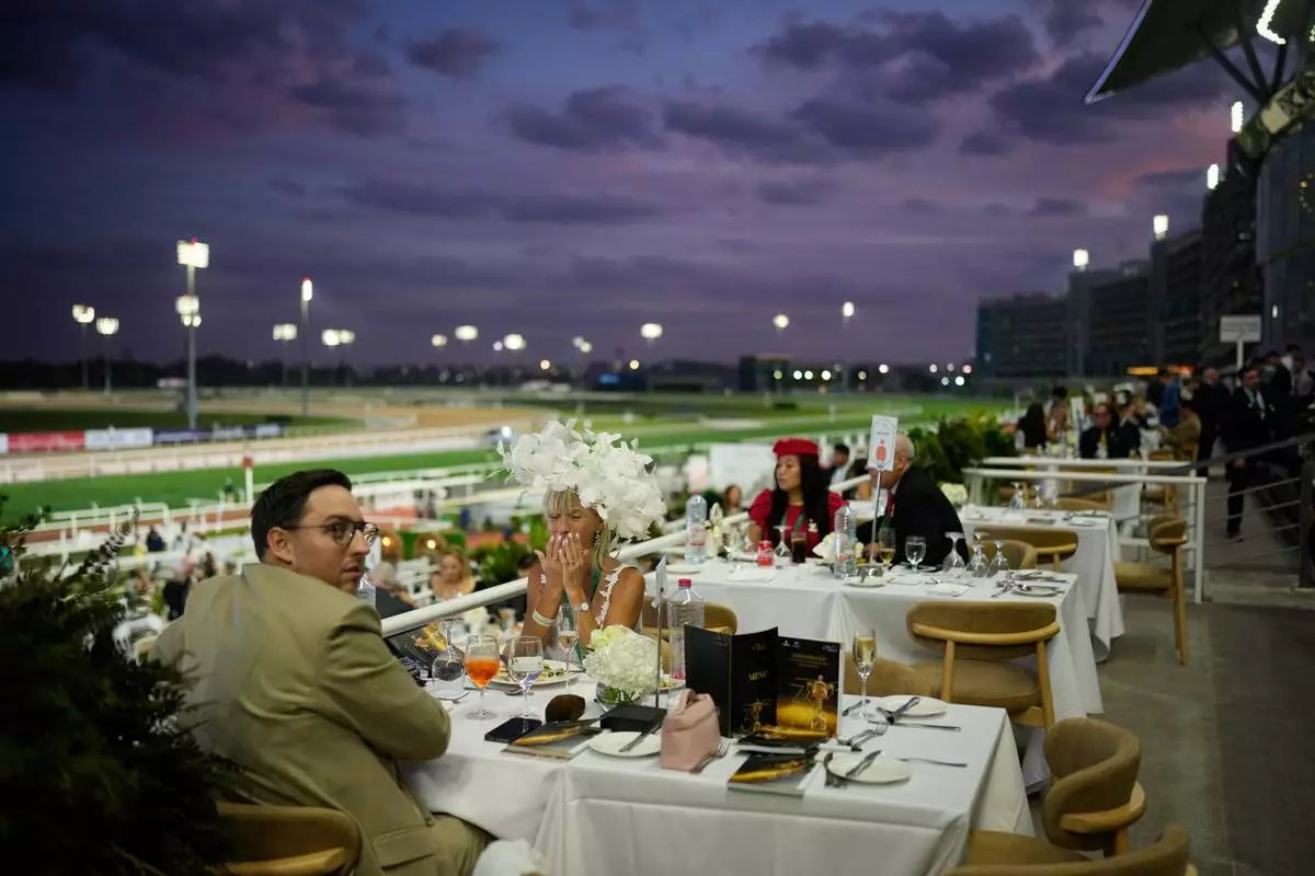 Racegoers dine at in the grandstand during the Dubai World Cup at Meydan Racecourse in Dubai, United Arab Emirates, Saturday, March 28, 2026. (AP Photo/Altaf Qadri)