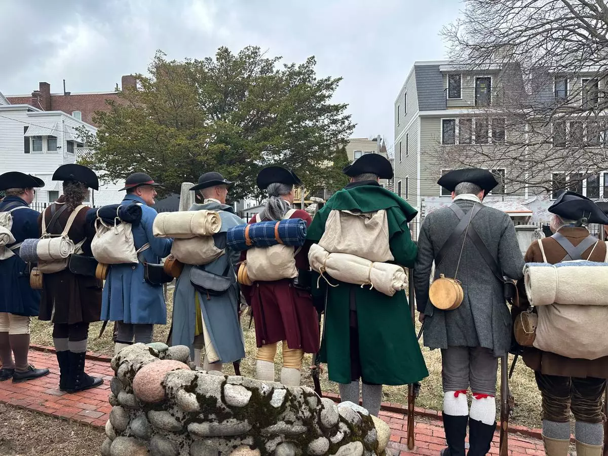 Revolutionary War reenactors line up outside St. Augustine Chapel and Cemetery in South Boston, Tuesday, March 17, 2026, before firing muskets during Evacuation Day commemorations marking the 250th anniversary of the British withdrawal from Boston. (AP Photo/Leah Willingham)