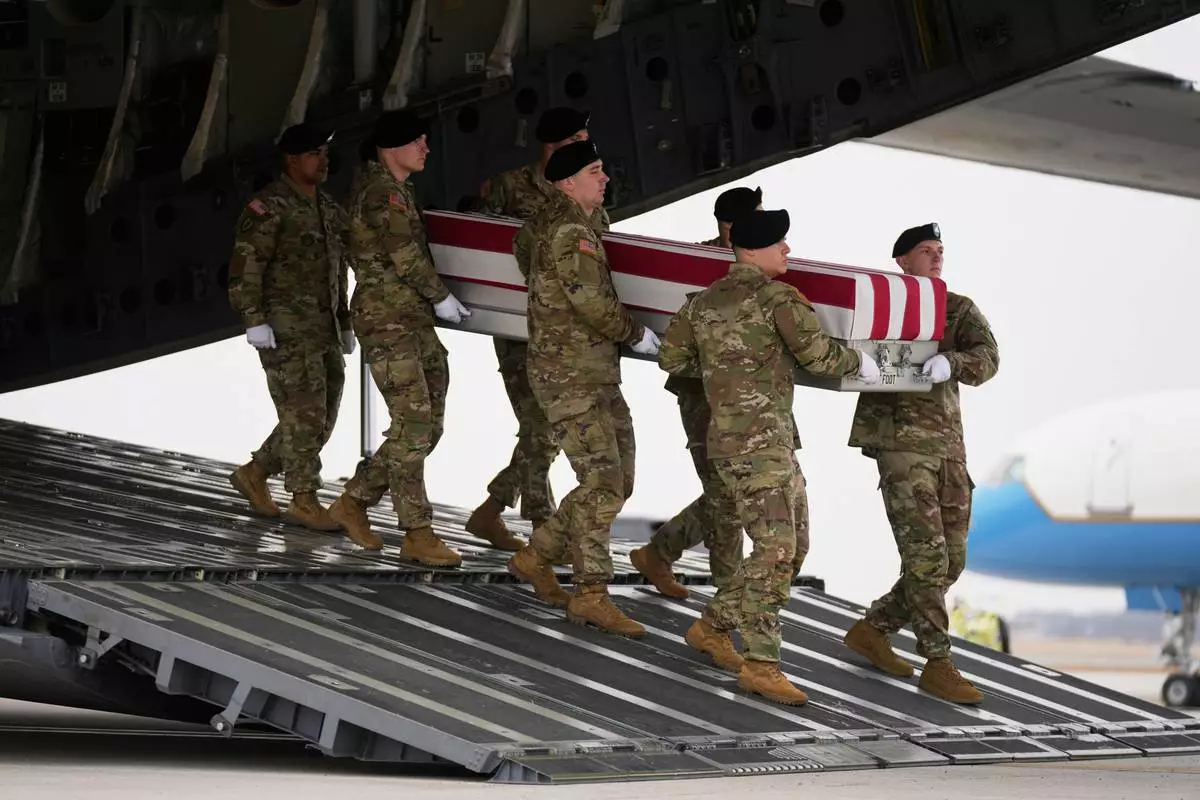 An Army carry team moves a flag-draped transfer case with the remains of Sgt. Declan Coady, 20, of West Des Moines, Iowa, who was killed in a drone strike at a command center in Kuwait after the U.S. and Israel launched its military campaign against Iran, past President Donald Trump and first lady Melania Trump during a casualty return, Saturday, March 7, 2026, at Dover Air Force Base, Del. (AP Photo/Mark Schiefelbein)