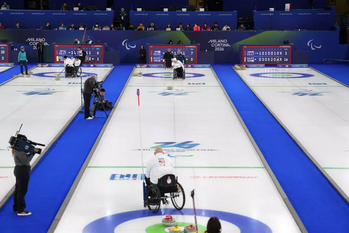 Steve Emt, foreground, and Laura Dwyer, center, of the United States, compete against Yoji Nakajima and Aki Ogawa, of Japan, in a wheelchair curling mixed doubles round robin session at the 2026 Winter Paralympics, in Cortina d'Ampezzo, Italy, Thursday, March 5, 2026. (AP Photo/Evgeniy Maloletka)