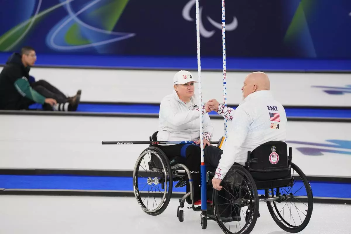 Steve Emt, right, and Laura Dwyer, of the United States, bump fists during their wheelchair curling mixed doubles round robin session against Japan at the 2026 Winter Paralympics, in Cortina d'Ampezzo, Italy, Thursday, March 5, 2026. (AP Photo/Evgeniy Maloletka)