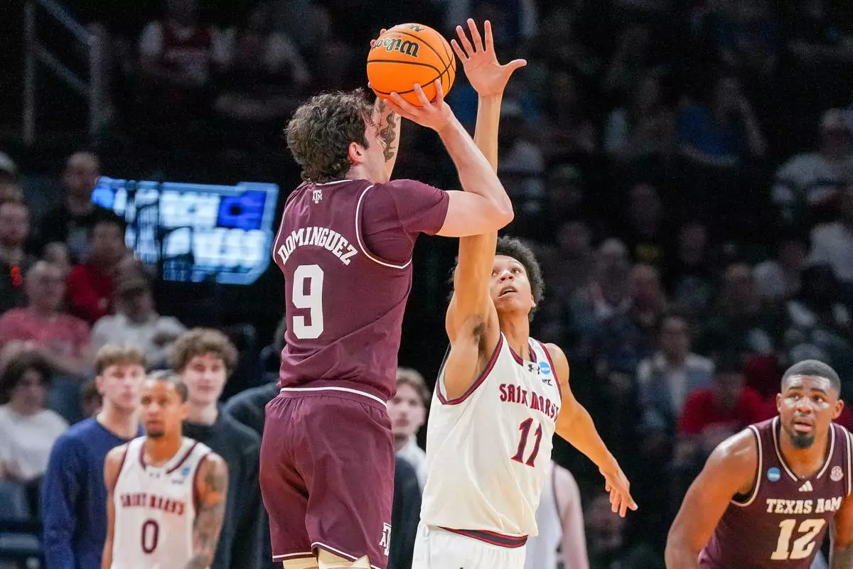 Saint Mary's guard Dillan Shaw (11) tries to block a shot by Texas A&amp;M guard Rubén Dominguez (9) during the first half in the first round of the NCAA college basketball tournament, Thursday, March 19, 2026, in Oklahoma City. (AP Photo/Kyle Phillips)
