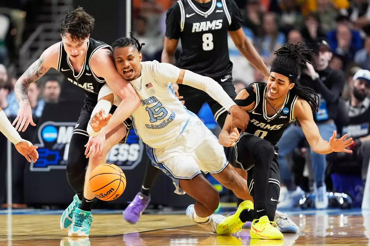 North Carolina forward Jarin Stevenson vies for the ball with VCU forward Lazar Djokovic, left, and guard Brandon Jennings during the second half in the first round of the NCAA college basketball tournament, Thursday, March 19, 2026, in Greenville, S.C. (AP Photo/Chris Carlson)