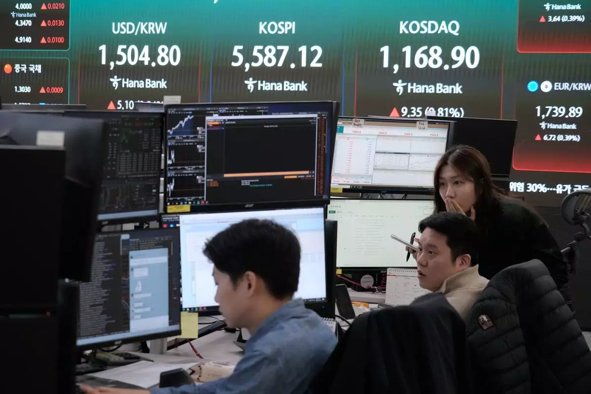 Currency traders watch monitors near a screen showing the Korea Composite Stock Price Index (KOSPI), top center, and the foreign exchange rate between U.S. dollar and South Korean won, top left, at the foreign exchange dealing room of the Hana Bank headquarters in Seoul, South Korea, Thursday, March 26, 2026. (AP Photo/Ahn Young-joon)