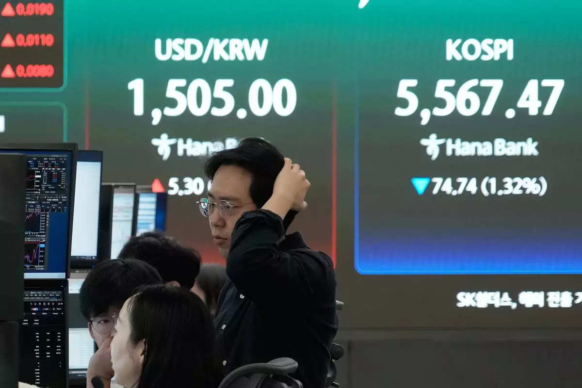 Currency traders watch monitors near a screen showing the Korea Composite Stock Price Index (KOSPI), right, and the foreign exchange rate between U.S. dollar and South Korean won at the foreign exchange dealing room of the Hana Bank headquarters in Seoul, South Korea, Thursday, March 26, 2026. (AP Photo/Ahn Young-joon)