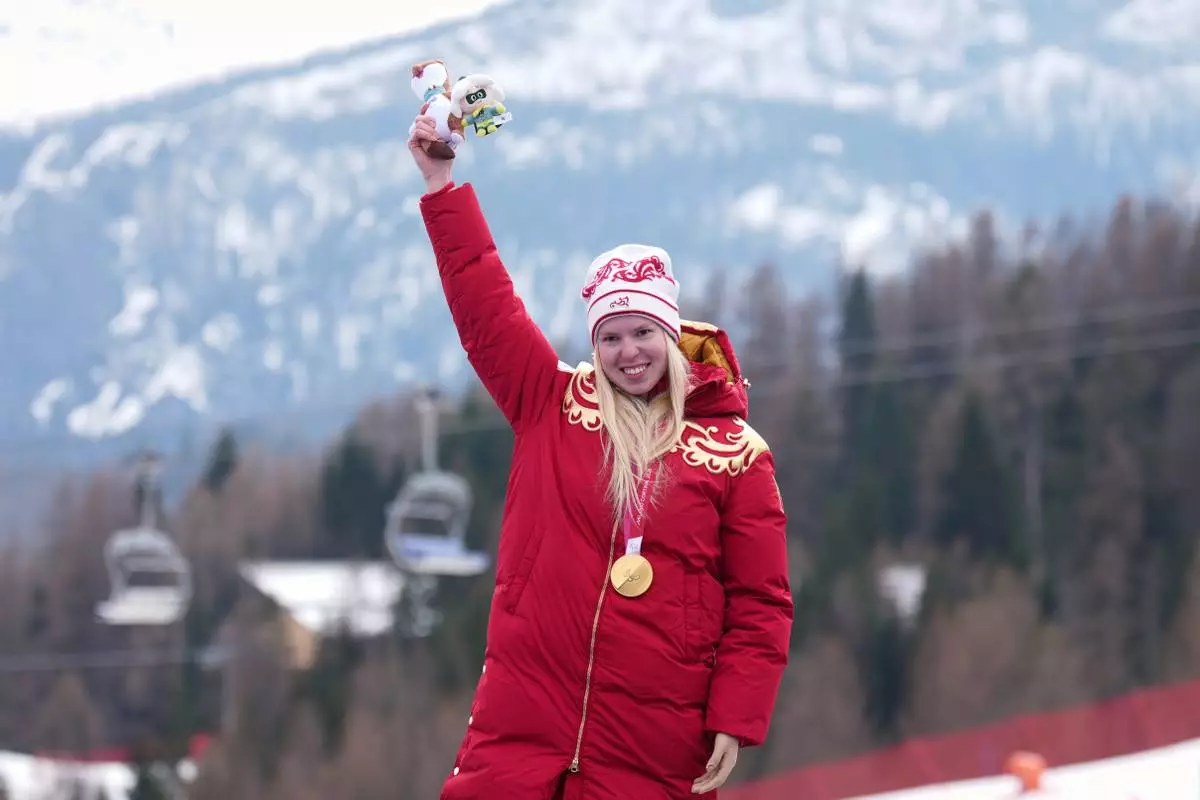 Varvara Voronchikhina, of Russia, smiles on the podium after winning the gold medal in the alpine skiing women's super-G standing at the 2026 Winter Paralympics, in Cortina d'Ampezzo, Italy, Monday, March 9, 2026. (AP Photo/Emilio Morenatti)