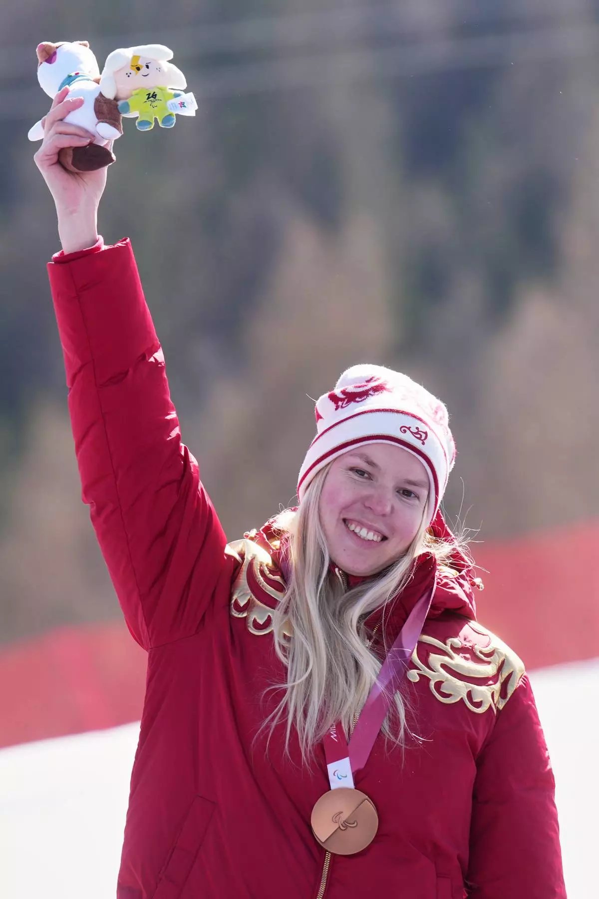 Varvara Voronchikhina, of Russia, stands on the podium after winning the bronze medal in the alpine skiing women's downhill standing competition at the 2026 Winter Paralympics, in Cortina d'Ampezzo, Italy, Saturday, March 7, 2026. (AP Photo/Emilio Morenatti)