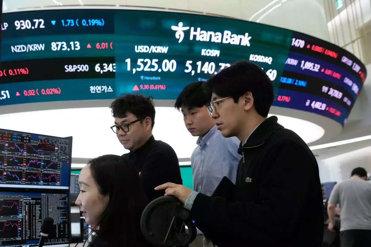 Currency traders watch monitors near a screen showing the Korea Composite Stock Price Index (KOSPI), top center, and the foreign exchange rate between U.S. dollar and South Korean won, top center left, at the foreign exchange dealing room of the Hana Bank headquarters in Seoul, South Korea, Tuesday, March 31, 2026. (AP Photo/Ahn Young-joon)