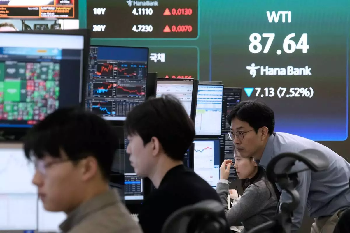 Currency traders work at the foreign exchange dealing room of the Hana Bank headquarters in Seoul, South Korea, Tuesday, March 10, 2026. (AP Photo/Ahn Young-joon)