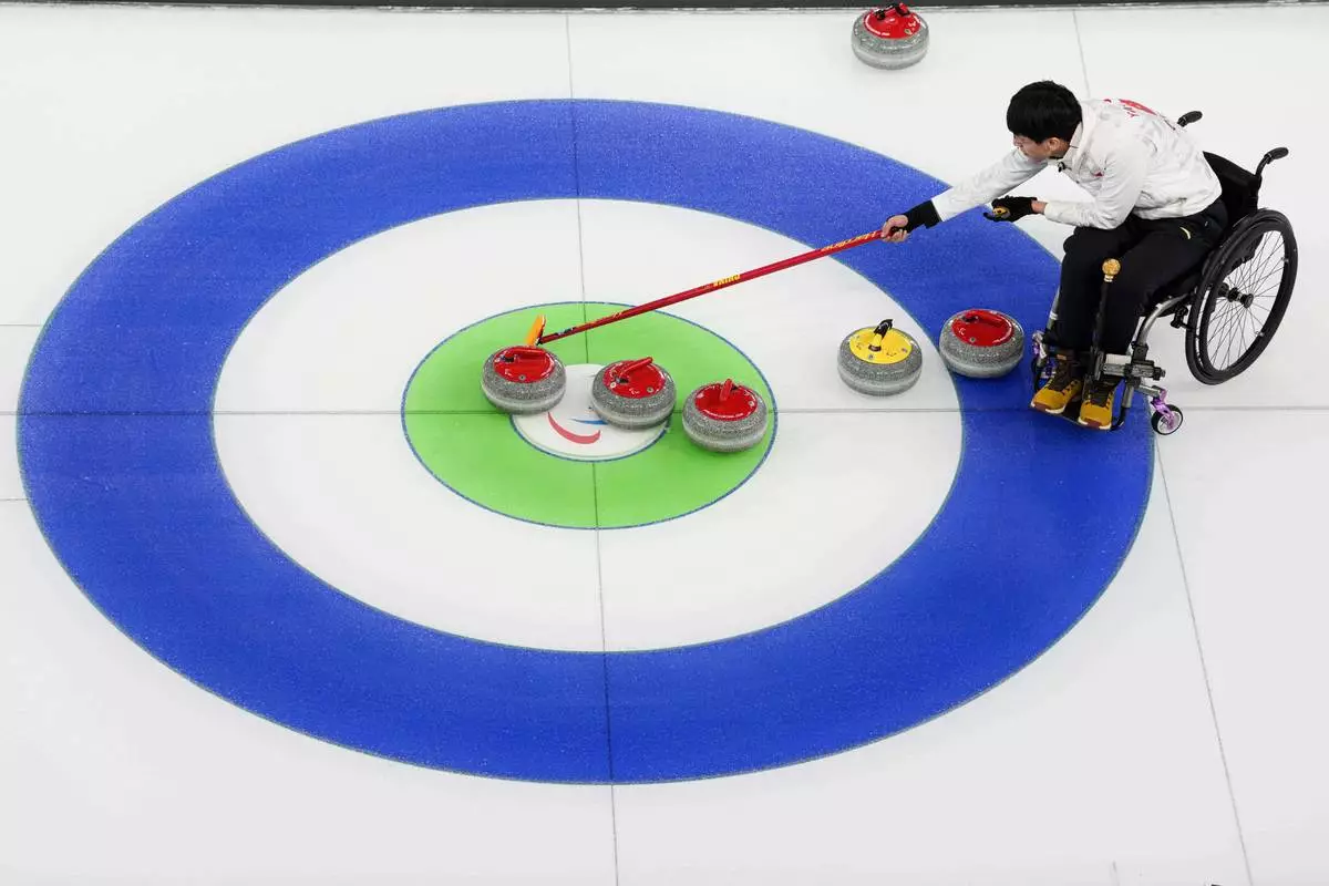 Jinqiao Yang, of China, competes during wheelchair curling mixed doubles round robin session against Italy at the 2026 Winter Paralympics, in Cortina d'Ampezzo, Italy, Thursday, March 5, 2026. (AP Photo/Evgeniy Maloletka)